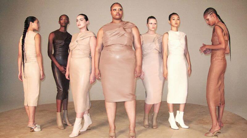 Vista de frente de uma diversidade de mulheres usando vestidos de couro em tons neutros. Mulheres gordas e magras de diferentes tons de pele.